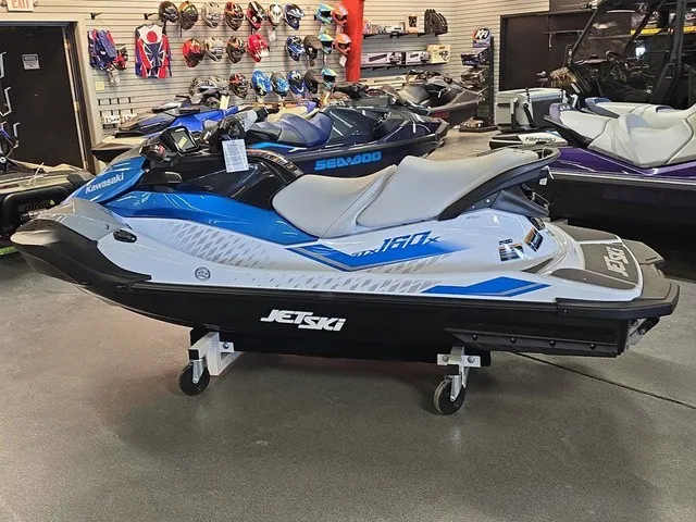 Slide: The Image of A 2026 Kawasaki Jet Ski STX is displayed in a showroom, surrounded by other personal watercraft. - 10