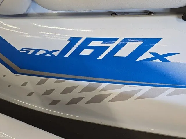 Slide: The Image of Close-up of blue "STX 160x" lettering on a white jet ski. - 11