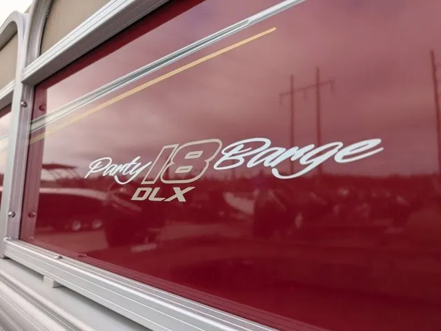 Slide: The Image of Close-up of the "Party Barge 18 DLX" lettering on a red boat. - 22