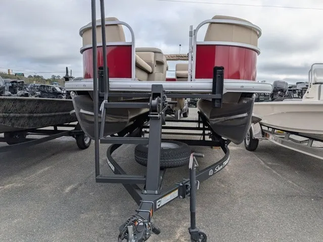 Slide: The Image of A 2025 Sun Tracker Party Barge 18 DLX on a trailer. It features red and beige accents. - 3
