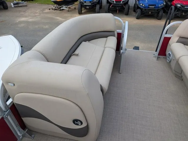 Slide: The Image of A sleek pontoon boat with beige upholstery and a curved seating area on a carpeted floor. - 12