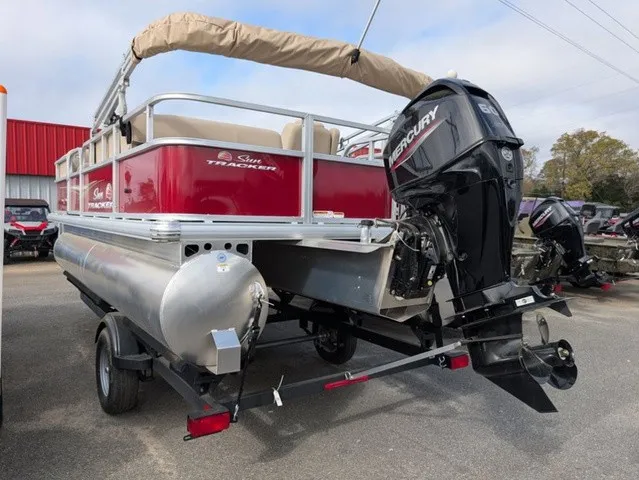Slide: The Image of A red pontoon boat with a Mercury outboard motor, parked on a trailer. - 30