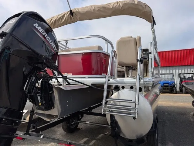 Slide: The Image of A 2025 Sun Tracker Party Barge 18 DLX with a Mercury outboard motor. It features beige seats and a red railing. - 26