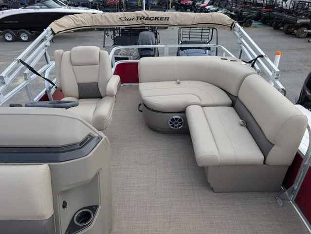 Slide: The Image of The image shows the deck of a Sun Tracker Party Barge 18 DLX pontoon boat with beige seating. - 10