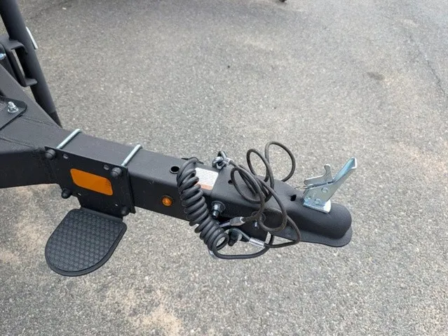 Slide: The Image of Close-up of a boat trailer hitch with cables and a step on asphalt. - 6