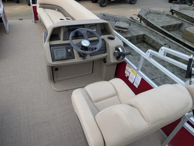 Slide: The Image of The image shows the cockpit of a 2025 Sun Tracker Party Barge 18 DLX with beige seating. - 16