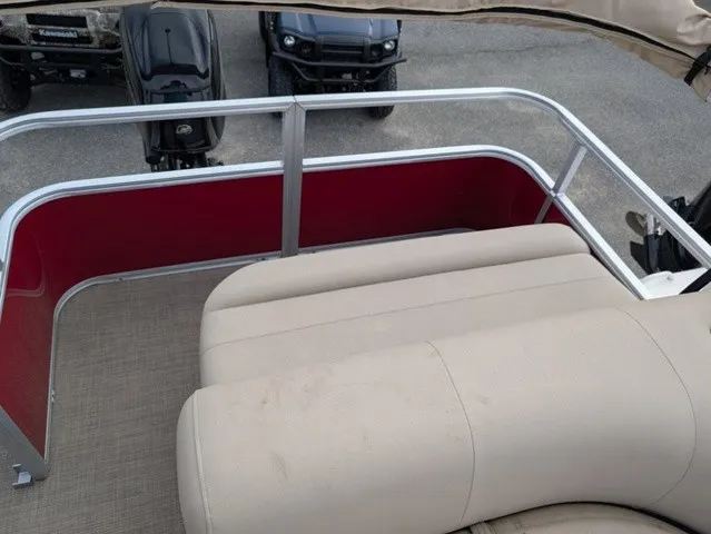Slide: The Image of A beige seating area on a pontoon boat with red railing and gray flooring. - 14
