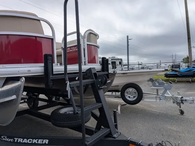 Slide: The Image of A 2025 Sun Tracker Party Barge 18 DLX on a trailer in a parking lot. - 5