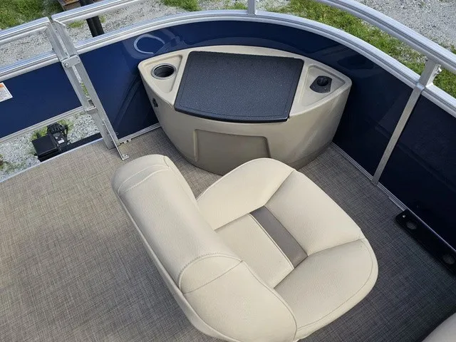 Slide: The Image of A beige cushioned seat on a boat with blue railing and gray flooring. - 19
