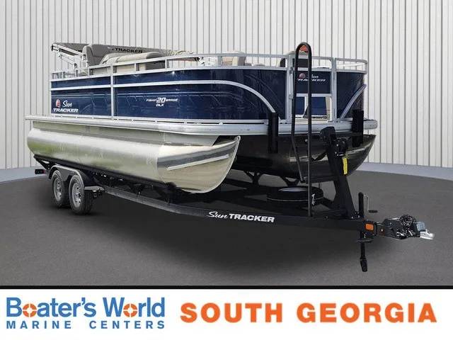 The Image of A 2025 Sun Tracker Fishin' Barge 20 DLX on a trailer in a showroom. - 1