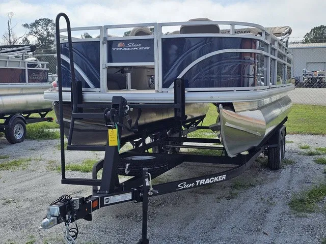 Slide: The Image of A 2025 Sun Tracker Fishin' Barge 20 DLX on a trailer, ready for the water. - 9