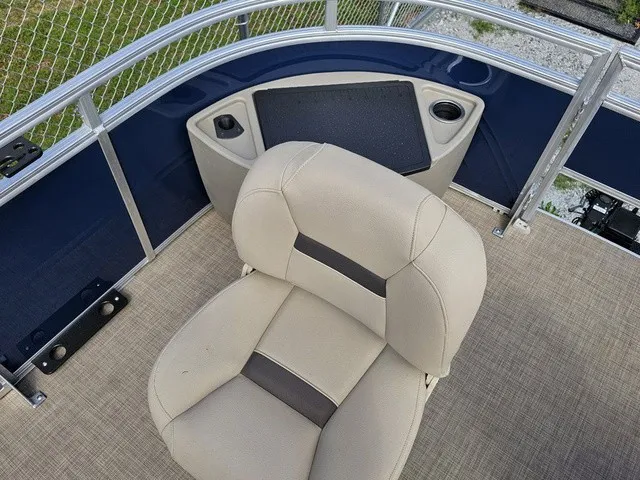 Slide: The Image of A beige seat on a 2025 Sun Tracker Fishin' Barge 20 DLX, surrounded by blue railings. - 20