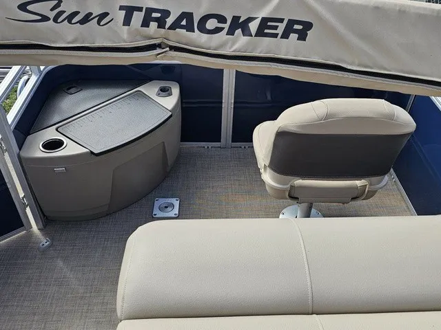 Slide: The Image of Interior of a Sun Tracker Fishin' Barge 20 DLX with beige seating and a helm console. - 10