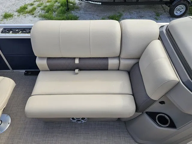 Slide: The Image of Beige seating on a boat with cup holder and speaker, surrounded by green grass. - 17
