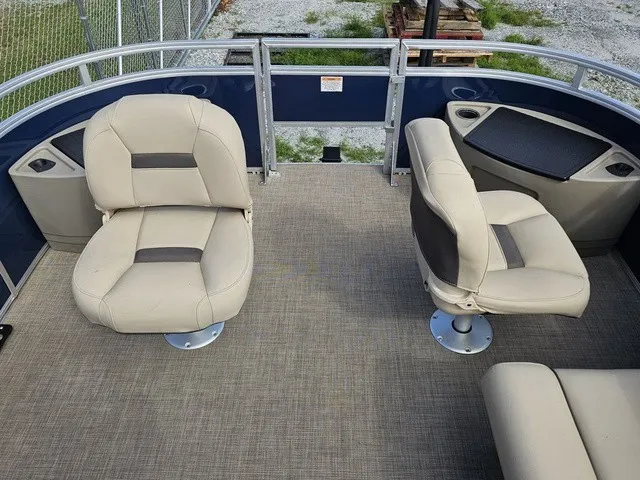 Slide: The Image of The image shows the deck of a Sun Tracker Fishin' Barge 20 DLX with two beige seats. - 18