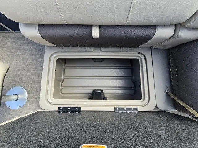 Slide: The Image of An open storage compartment on a boat with cushioned seats and textured flooring. - 27