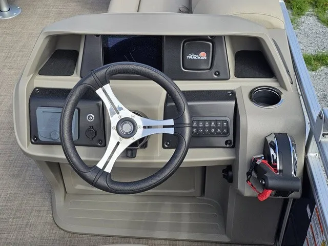 Slide: The Image of The image shows the helm of a 2025 Sun Tracker Fishin' Barge 20 DLX with a modern steering wheel and controls. - 21