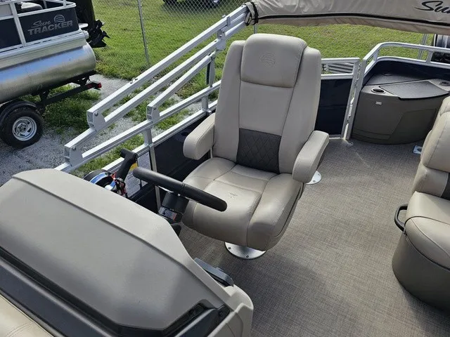Slide: The Image of The image shows the helm of a 2025 Sun Tracker Fishin' Barge 20 DLX with comfortable seating. - 16