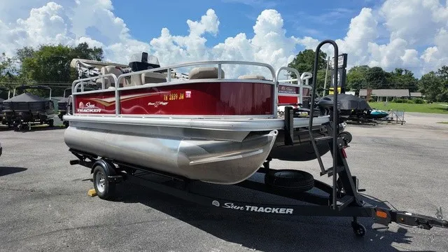 Slide: The Image of A red pontoon boat on a trailer, surrounded by trees and other boats. - 6