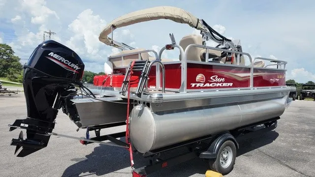 Slide: The Image of A 2025 Sun Tracker Bass Buggy 16 XL Select pontoon boat on a trailer, featuring a Mercury outboard motor. - 4