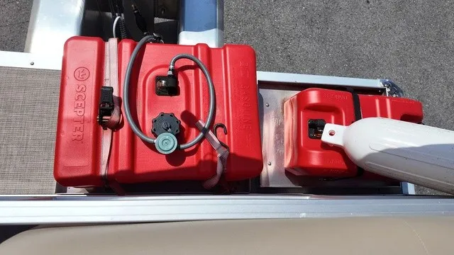 Slide: The Image of Two red fuel tanks are mounted on a boat, with hoses and connectors visible. - 19