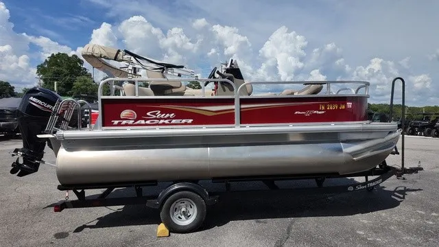 Slide: The Image of A 2025 Sun Tracker Bass Buggy 16 XL Select on a trailer, featuring a red hull and beige interior. - 5
