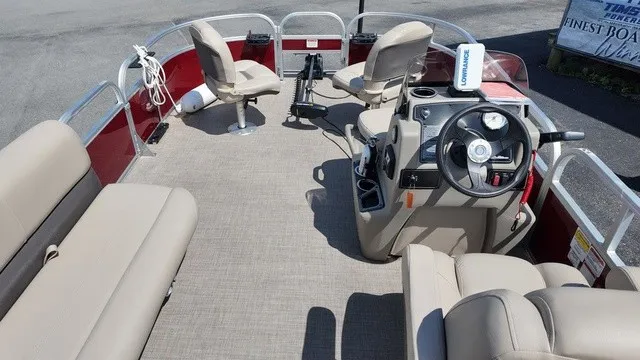 Slide: The Image of The image shows a pontoon boat with beige seating and a helm station. It has red side panels. - 20