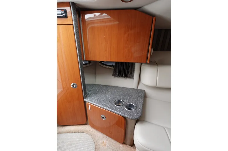 Slide: The Image of Interior of a 2005 Formula 280 Sun Sport with wood cabinets, gray countertop, and cup holders. - 47