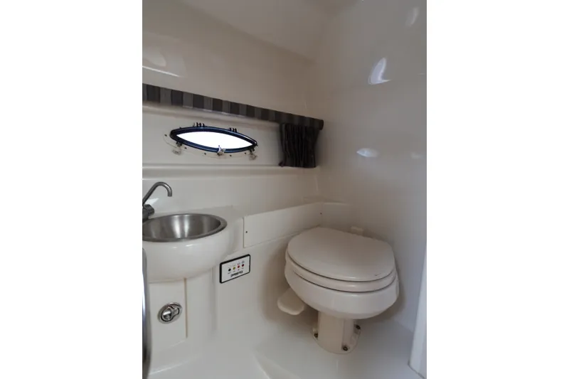 Slide: The Image of 2005 Formula 280 Sun Sport boat bathroom with sink, toilet, and porthole window. - 60