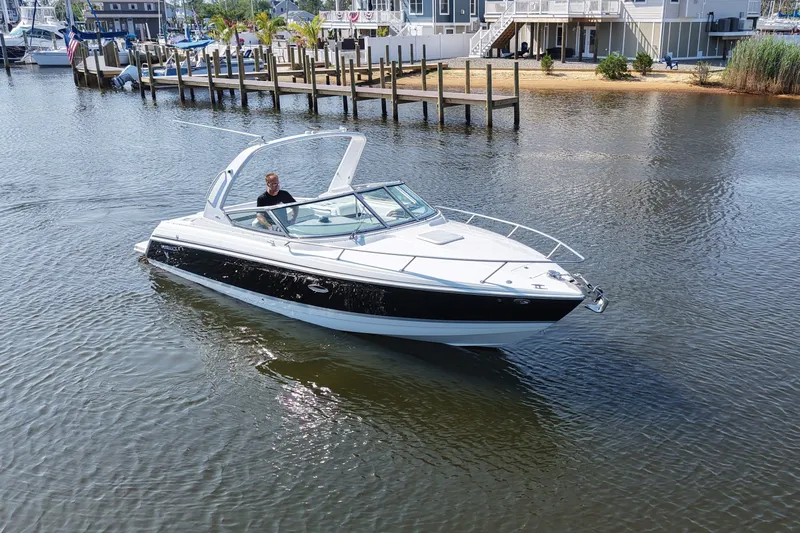Slide: The Image of A white and black motorboat cruising on calm water, with a person at the helm. - 7