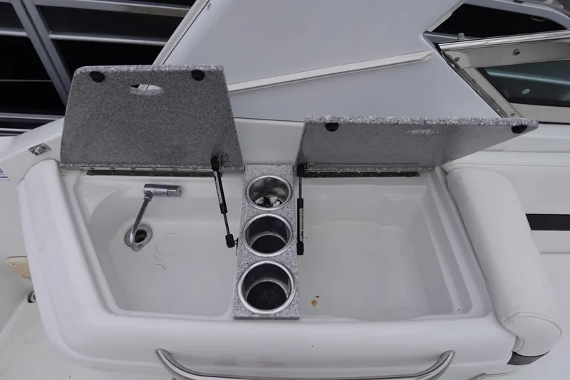 Slide: The Image of Open storage compartment with cup holders on a Formula 280 Sun Sport boat. - 35