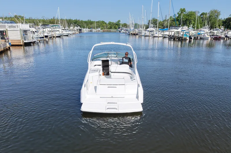 Slide: The Image of A white motorboat navigates through a calm harbor with numerous sailboats in the background. - 12