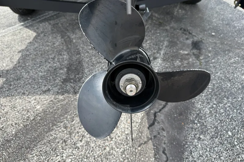 Slide: The Image of Propeller of 2024 Tracker Pro Team 175 TF boat on asphalt surface. - 20