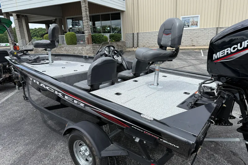 Slide: The Image of 2024 Tracker Pro Team 175 TF fishing boat with Mercury engine, parked outdoors. - 25
