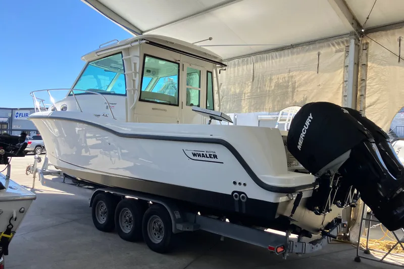 Slide: The Image of 2019 Boston Whaler 315 Conquest Pilothouse on trailer, under canopy. - 13