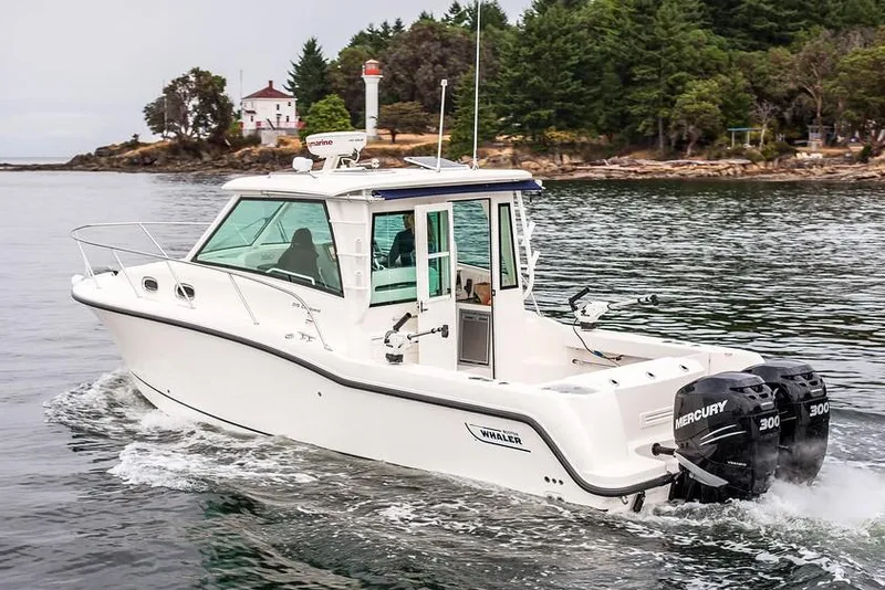 Slide: The Image of Manufacturer Provided Image: 2019 Boston Whaler 315 Conquest Pilothouse boat cruising on a lake near a forested shoreline. - 3