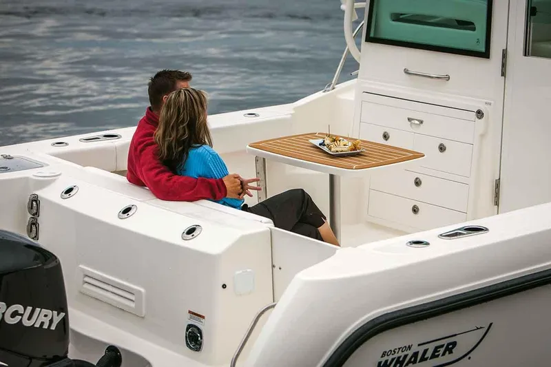 Slide: The Image of Manufacturer Provided Image: Couple relaxing on a 2019 Boston Whaler 315 Conquest Pilothouse boat. - 6