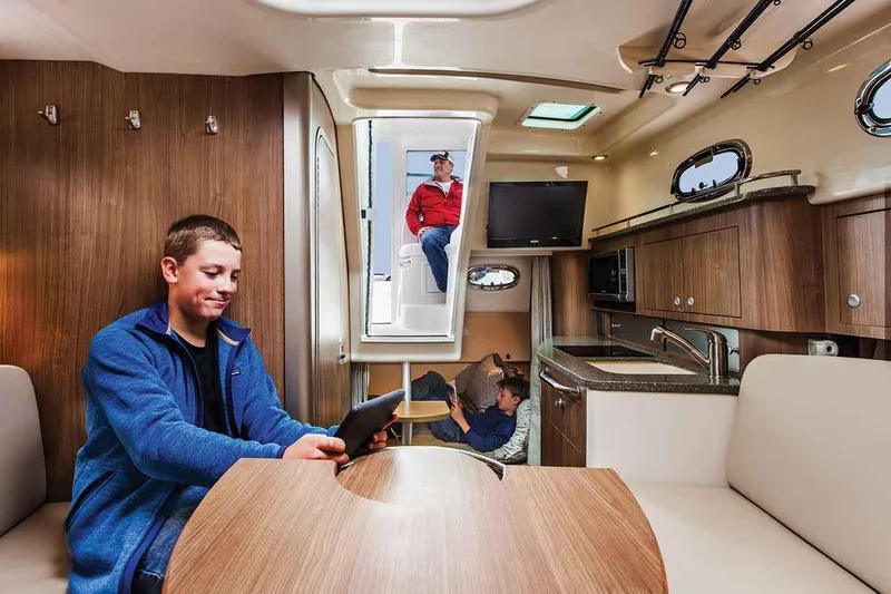 Slide: The Image of Manufacturer Provided Image: Interior of 2019 Boston Whaler 315 Conquest Pilothouse with people relaxing. - 8