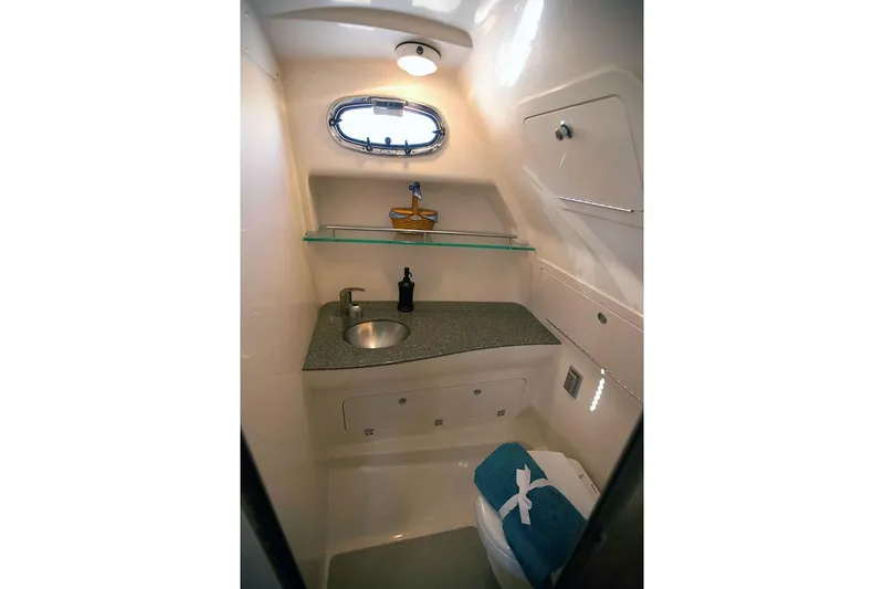 Slide: The Image of Manufacturer Provided Image: 2019 Boston Whaler 315 Conquest Pilothouse bathroom with sink, storage, and porthole window. - 10