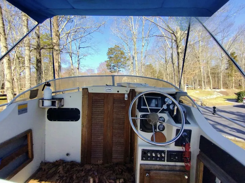Slide: The Image of The cockpit of a 1983 Boston Whaler 25 Revenge with a wooden steering wheel and control panel. - 15