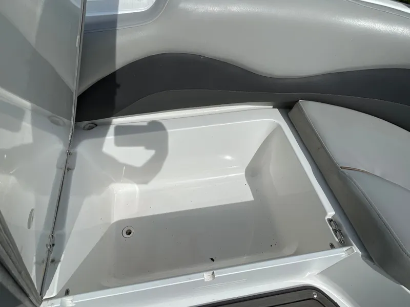Slide: The Image of An open storage compartment on a boat with gray upholstery and a white interior. - 27