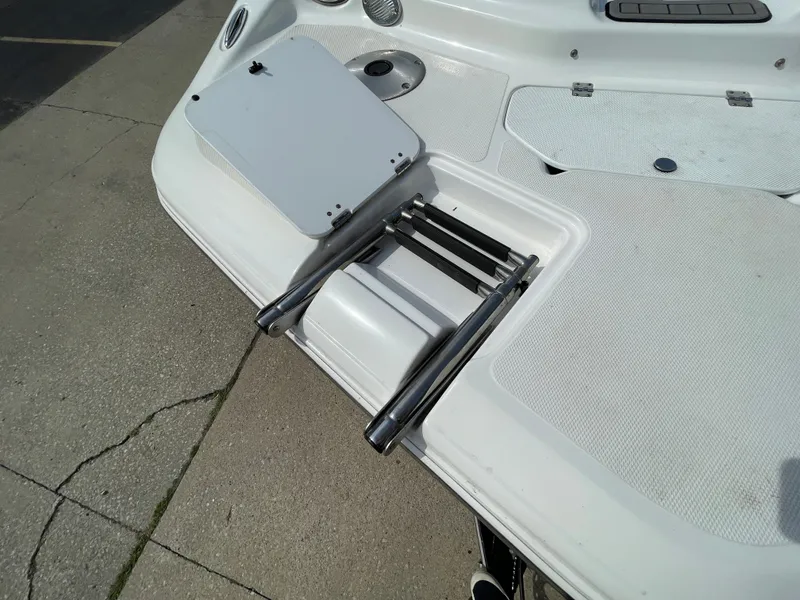 Slide: The Image of A white boat with a retractable swim ladder at the stern, parked on a concrete surface. - 12