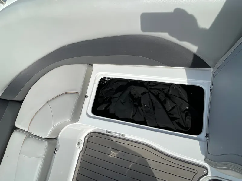 Slide: The Image of An open storage compartment on a boat with black clothing inside. - 32