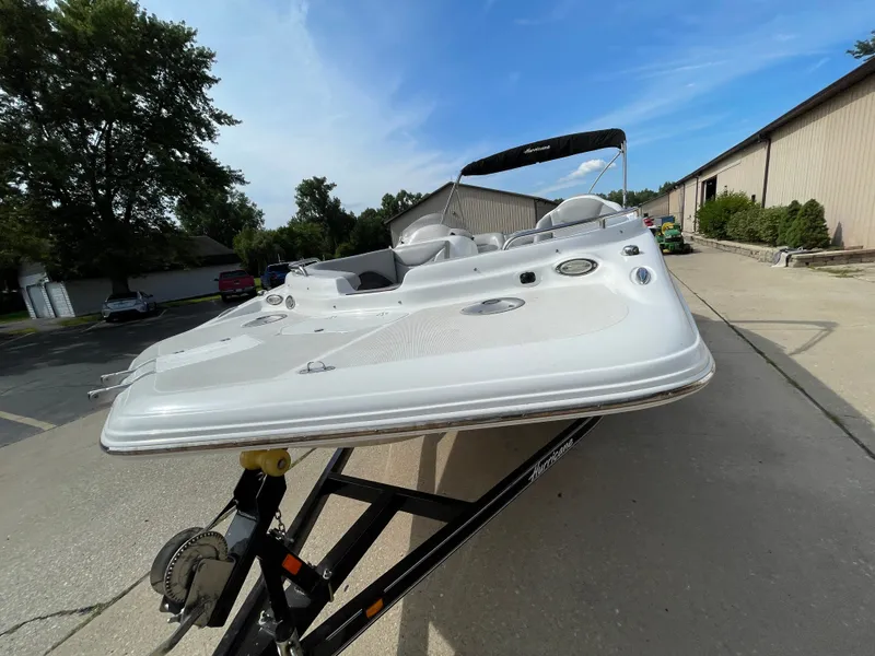 Slide: The Image of A 2018 Hurricane SS202 on a trailer, featuring an open deck and seating area. - 10