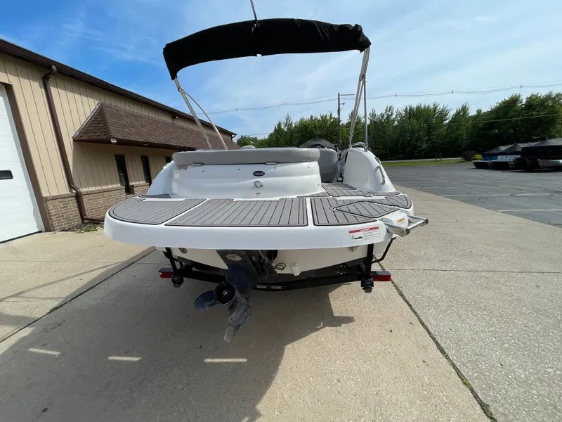 Slide: The Image of A 2018 Hurricane SS202 boat with an open deck and black sunshade, parked on a concrete lot. - 4