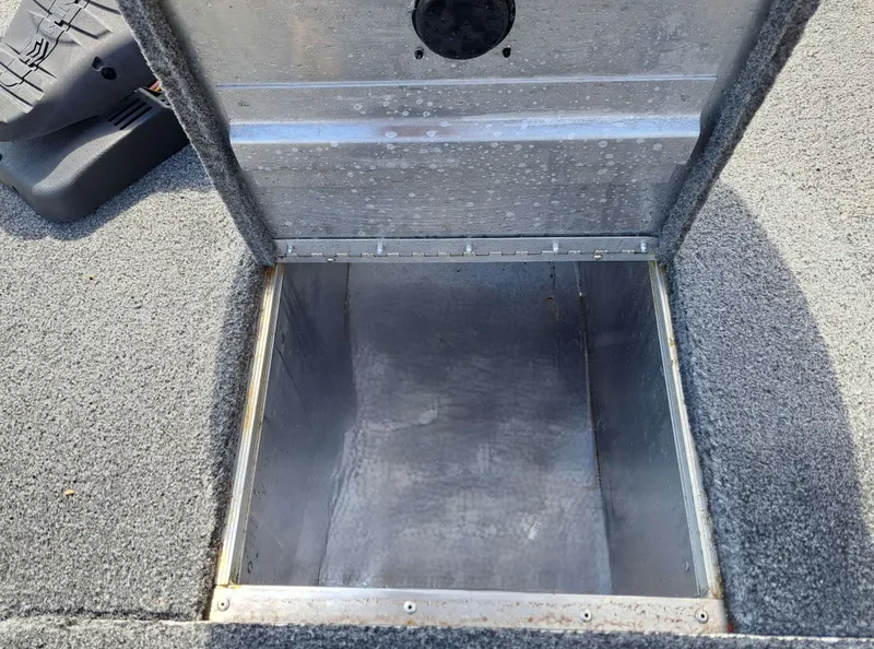 Slide: The Image of An open storage compartment on a Tracker Pro 170 boat, surrounded by gray carpeting. - 13