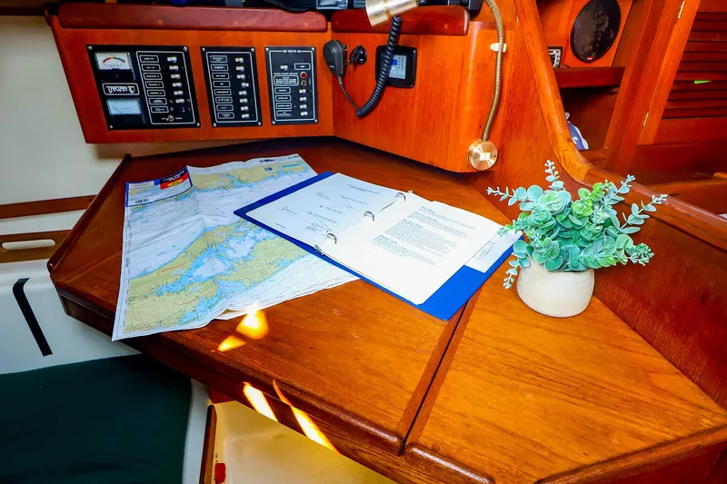 Slide: The Image of Navigation station on 1988 Tartan 34-2 sailboat with map, documents, and plant. - 39