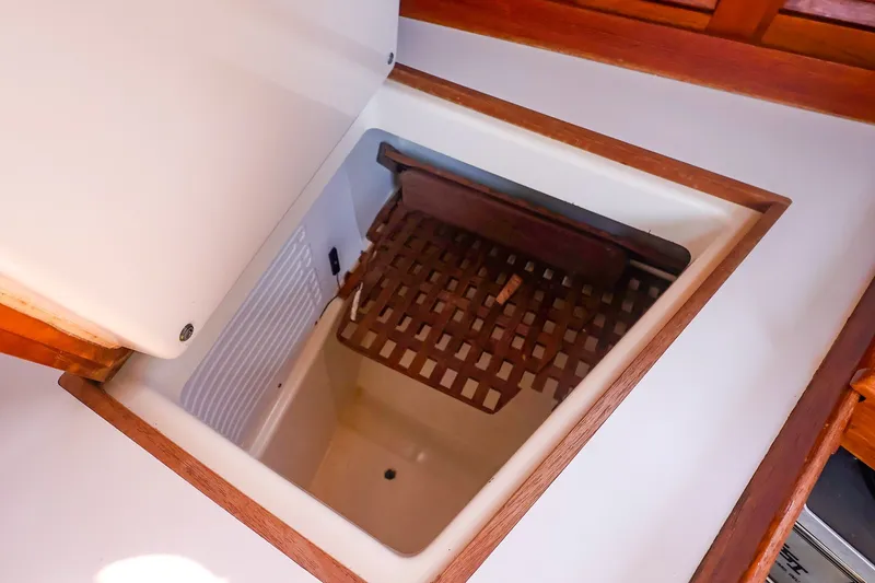 Slide: The Image of Open storage compartment on 1988 Tartan 34-2 sailboat with wooden trim and lattice shelf. - 34