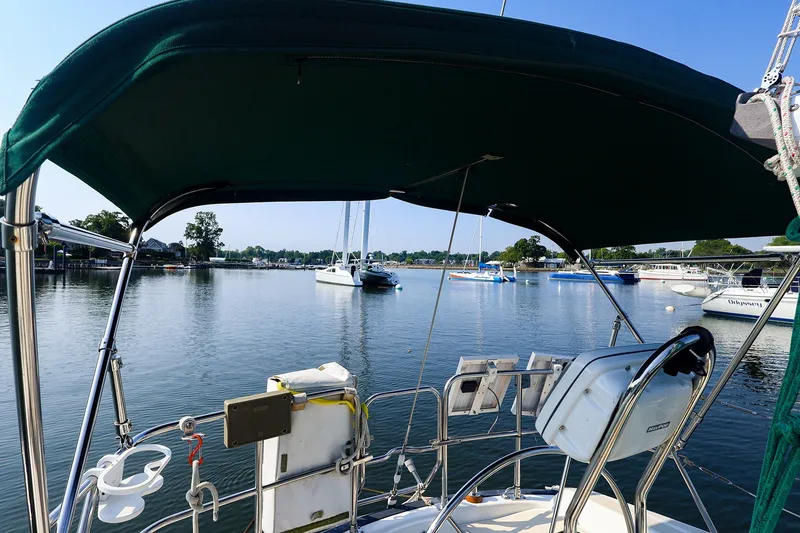 Slide: The Image of 1988 Tartan 34-2 sailboat cockpit view, overlooking a serene marina with moored boats. - 13