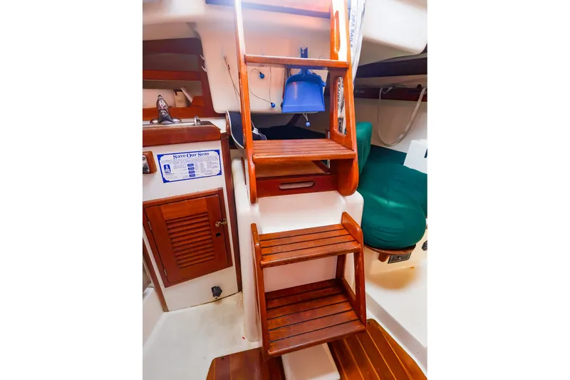 Slide: The Image of Interior of 1988 Tartan 34-2 sailboat with wooden steps and cozy seating area. - 25